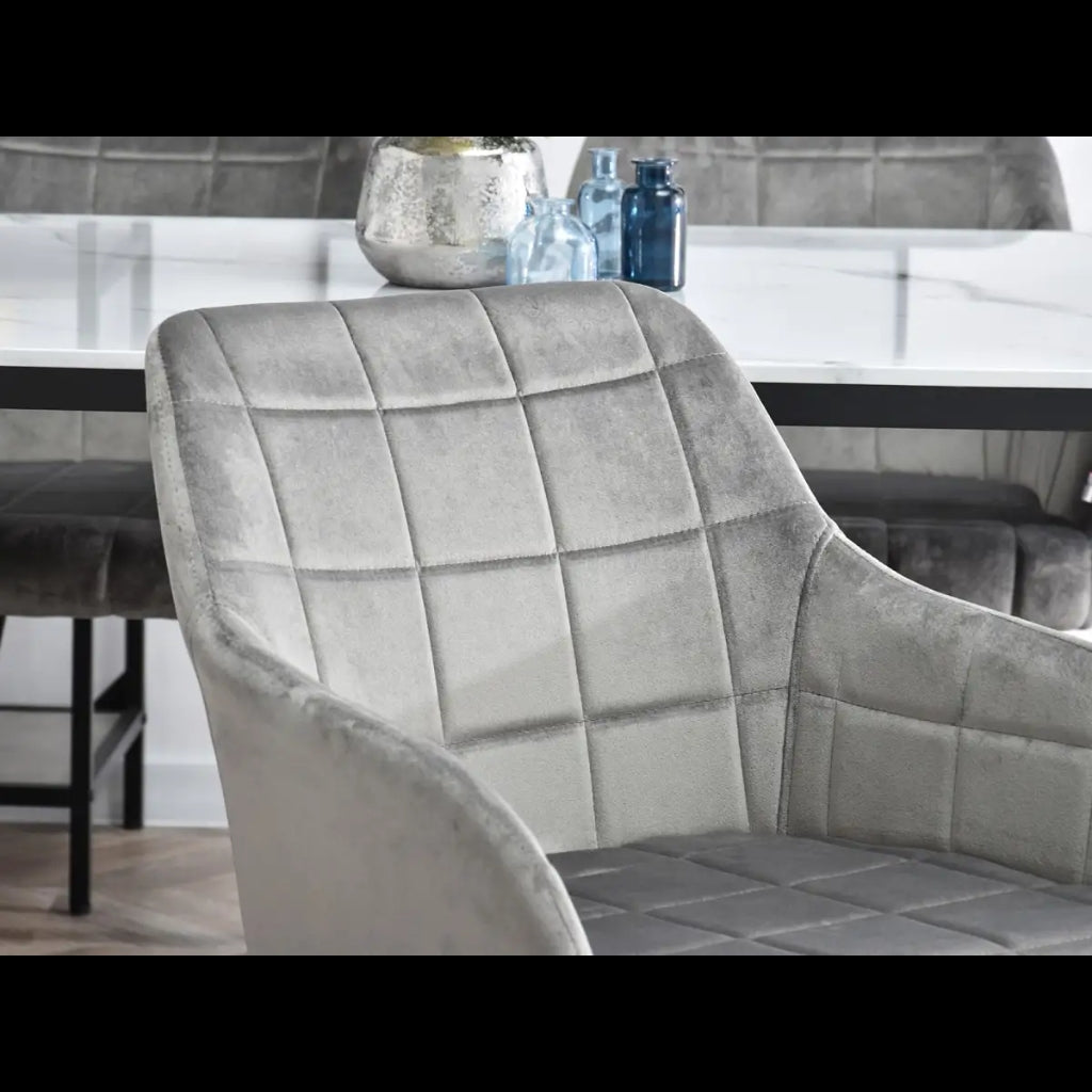 chic grey velvet dining chair and a contrasting black and white table.
