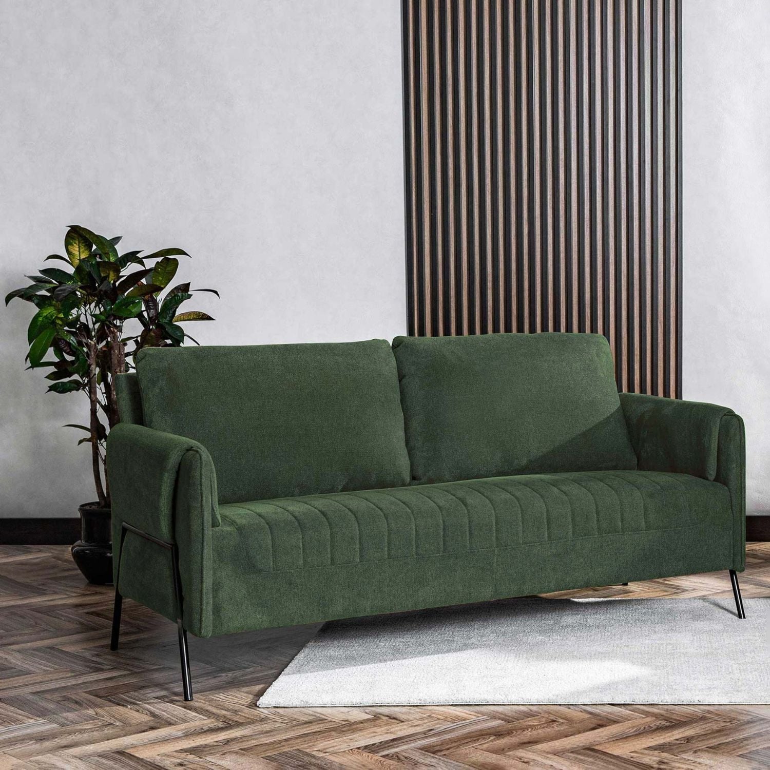 Kreslo Green 2-Seater Sofa in a modern living room setting with a plant.