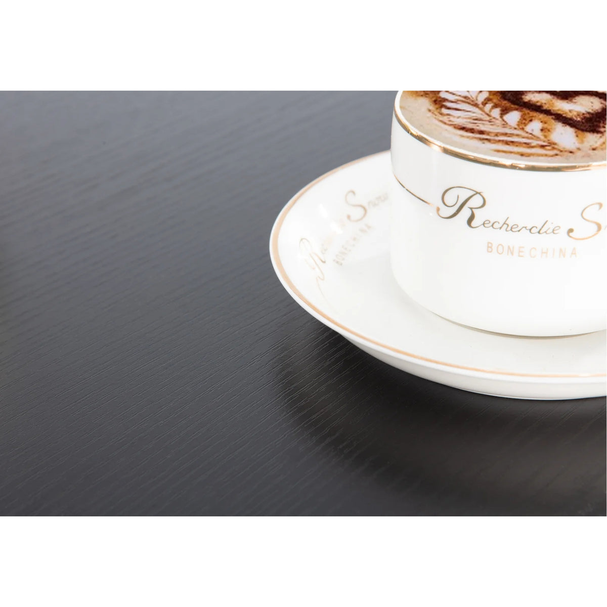 a cup of coffee placed on kiana desk with black wood finish