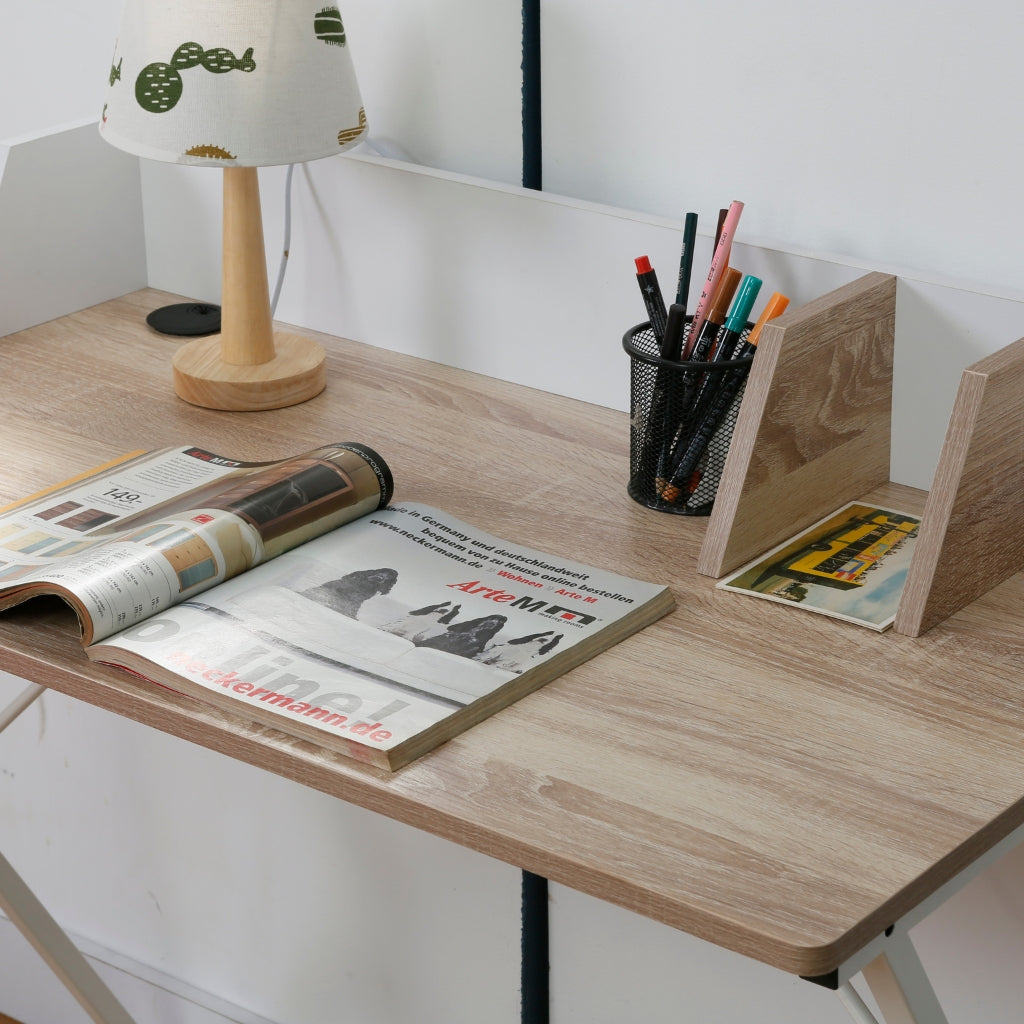 A farmhouse-style Wanda computer desk with a lamp, magazine, and a lampshade.