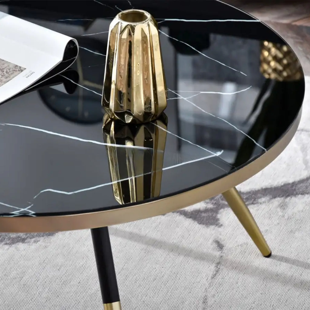 A modern coffee table named Estella, showcasing gold legs and a sleek black marble top.