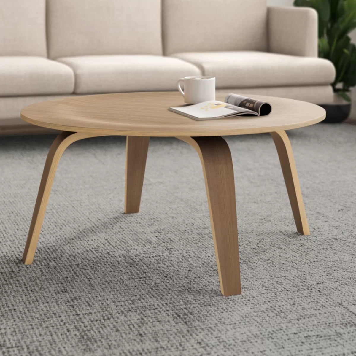 A modern coffee table with a round wooden base, REPLICA EAMES MOLDED PLYWOOD COFFEE TABLE in ash-wood.