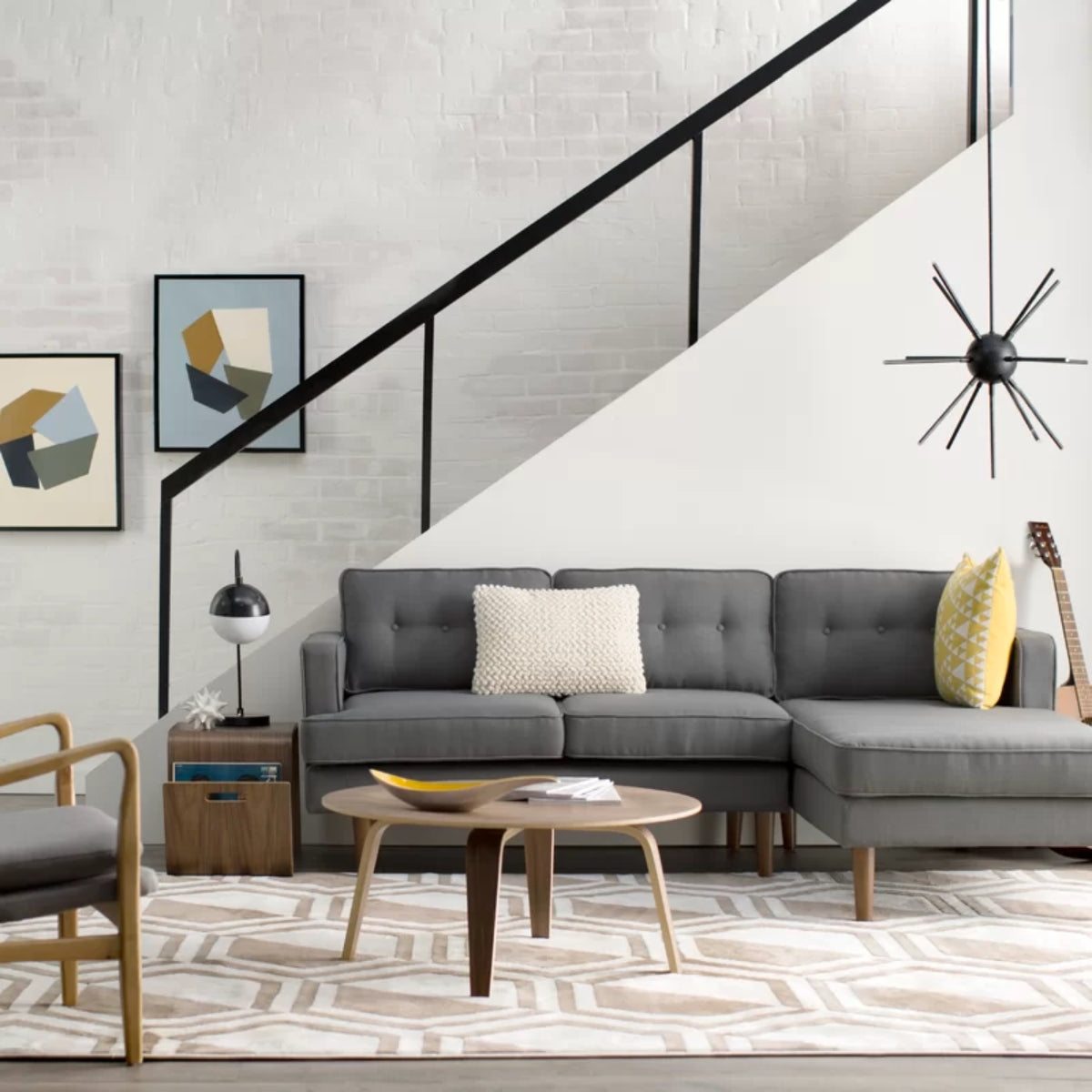 A modern living room with a gray sofa, chair, rug, and a replica Eames molded plywood coffee table.