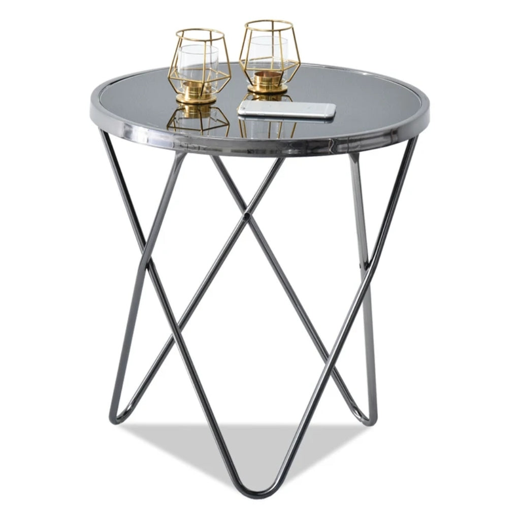 A round glass table with metal legs and a candle.