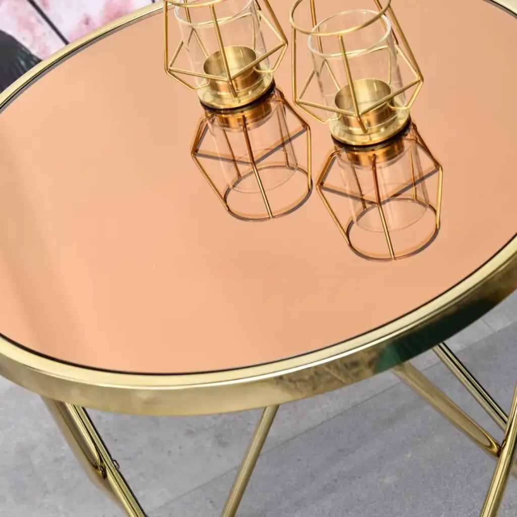 A shiny gold side table named Aden with two bowls resting on it.