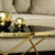A stunning gold coffee table adorned with a sophisticated black marble tabletop.