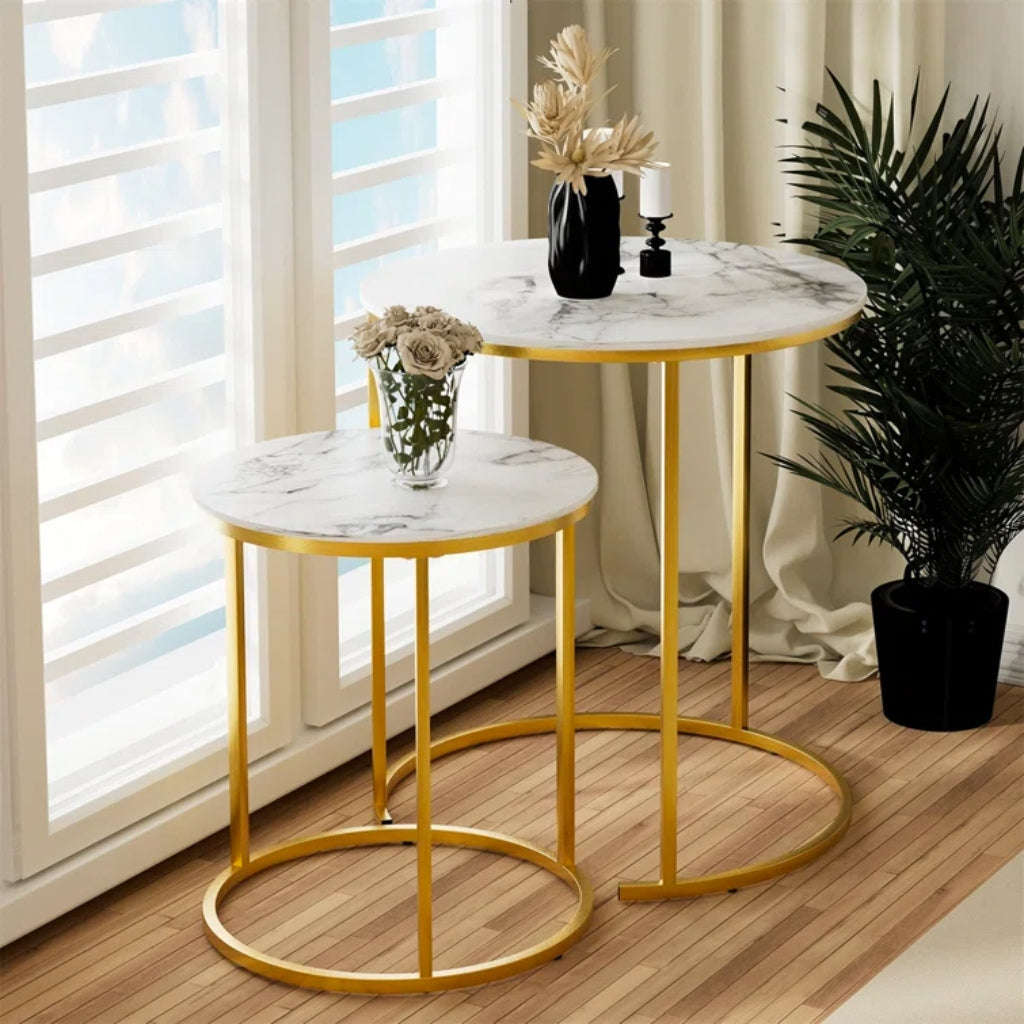 A stylish Dalia Nesting End Table Set Gold with a round marble top, gold legs.