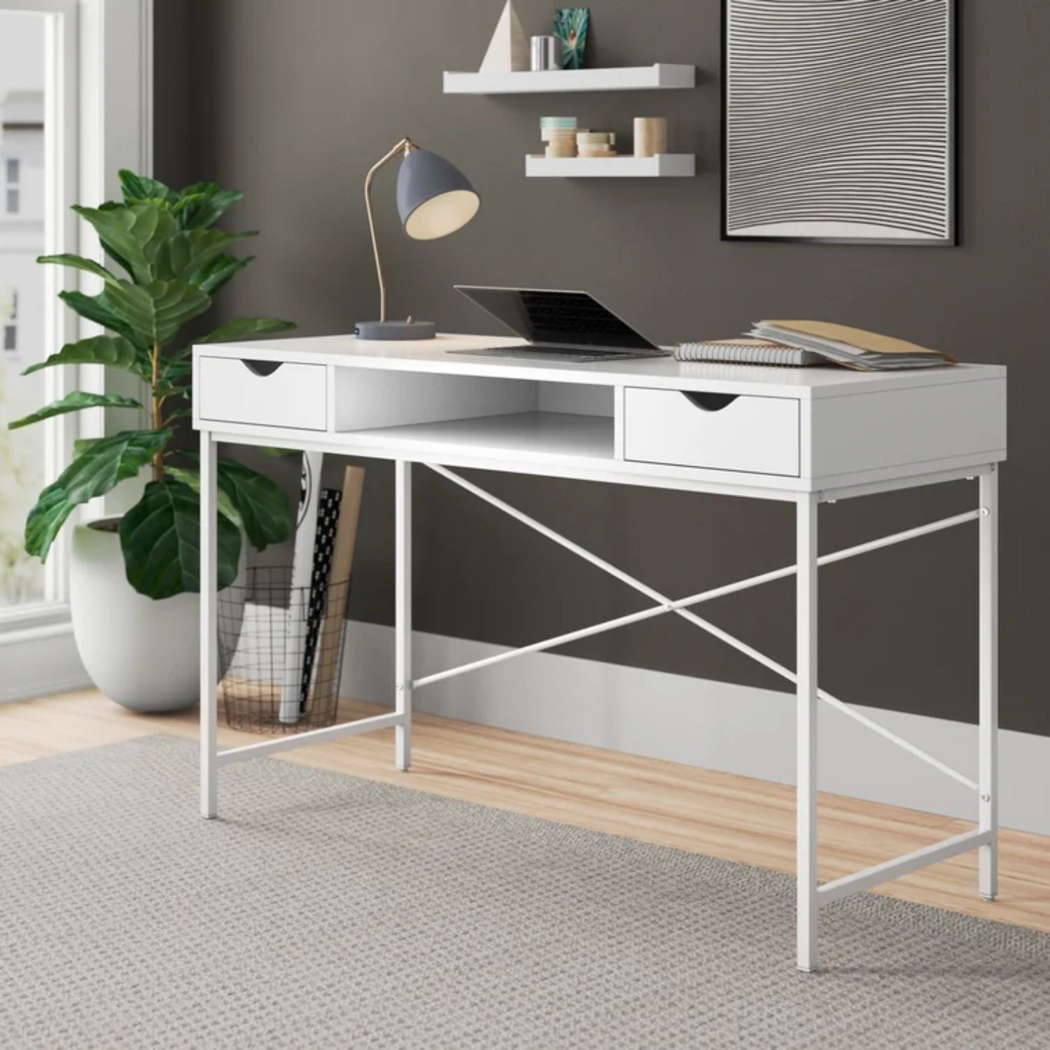 a white desk with drawers and a plant