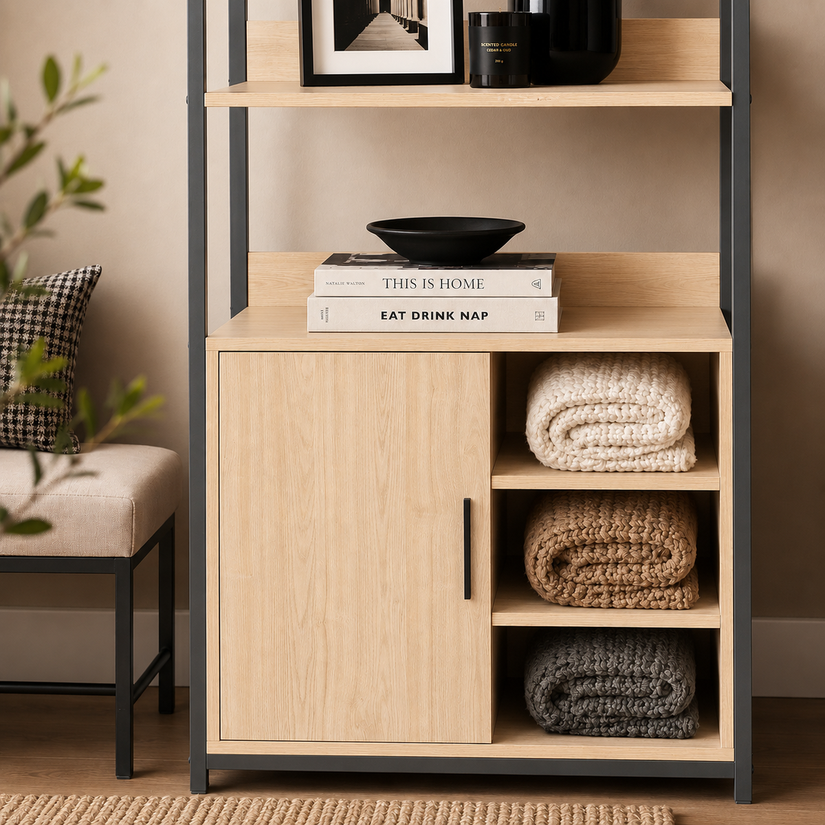 A light oak wood and black metal storage cabinet with open shelves on top and a single drawer at the bottom, styled with a potted green plant and books in a home setting.