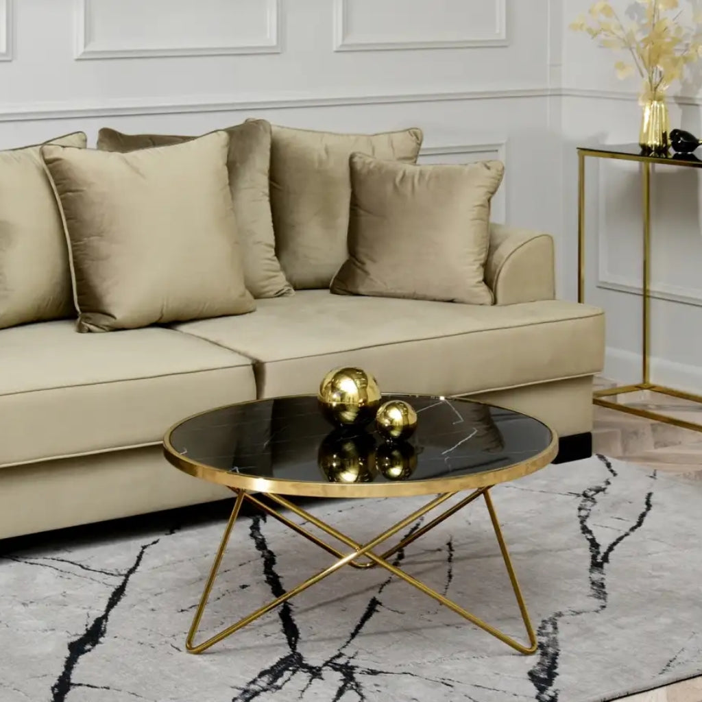 An elegant coffee table featuring a gold frame and a stylish black marble top.