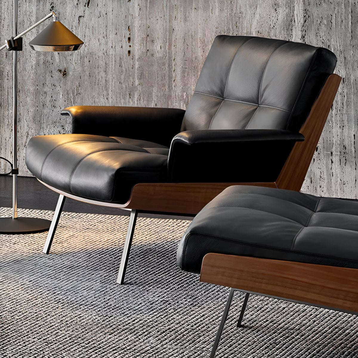 An elegant Replica Daiki black leather lounge chair and ottoman positioned against a wall.