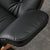 Close-up of black leather armrest on the Eames lounge chair.