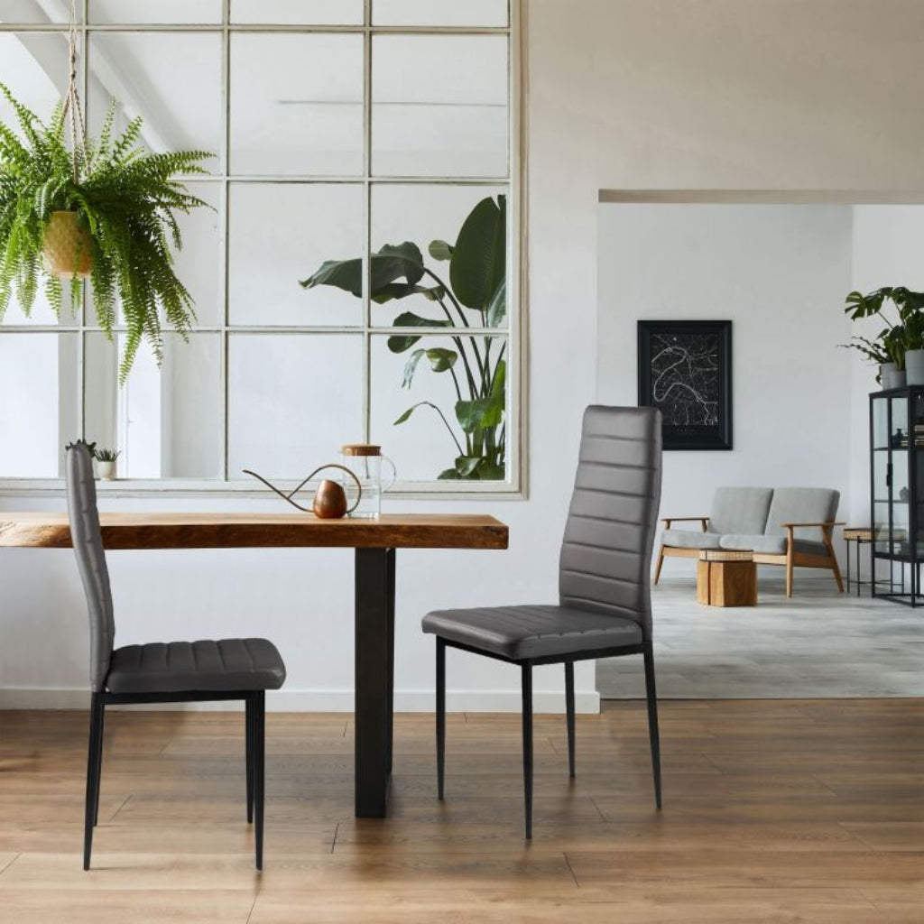 East Urban stylish dark grey pu chairs in a contemporary dining area with a table and chairs.