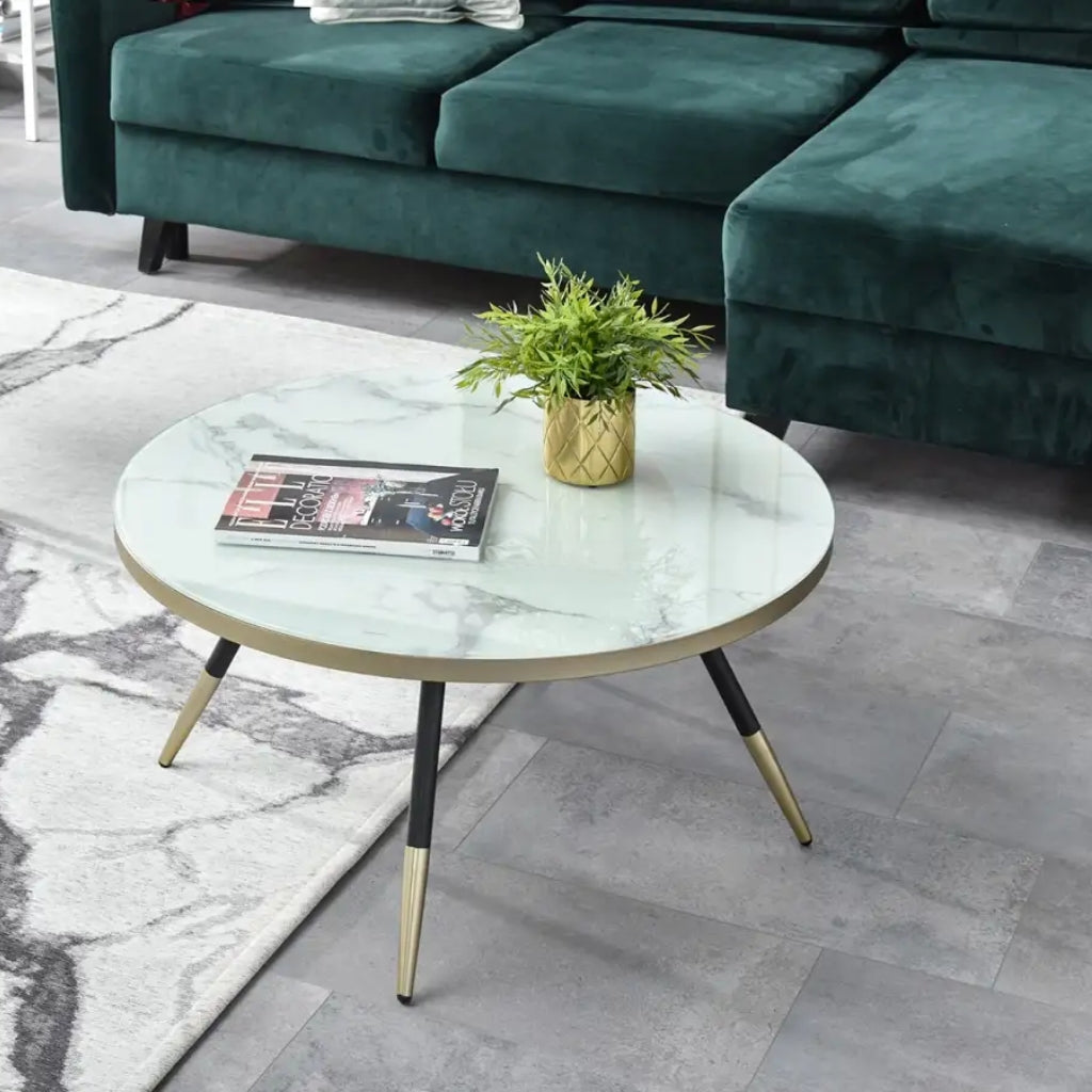 A sleek Estella black coffee table with gold legs and a black marble top.