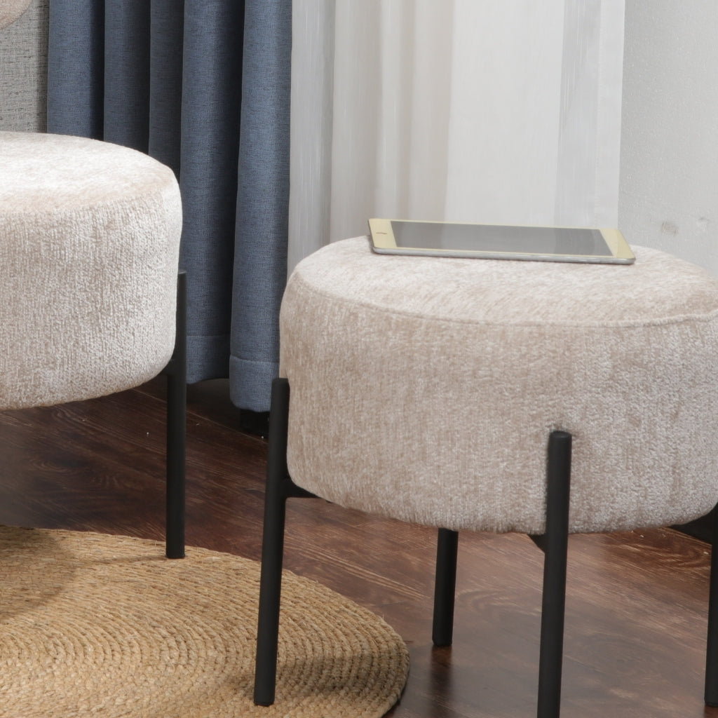 Monroe round stool with black legs and a beige fabric providing comfortable seating in a neutral color scheme.