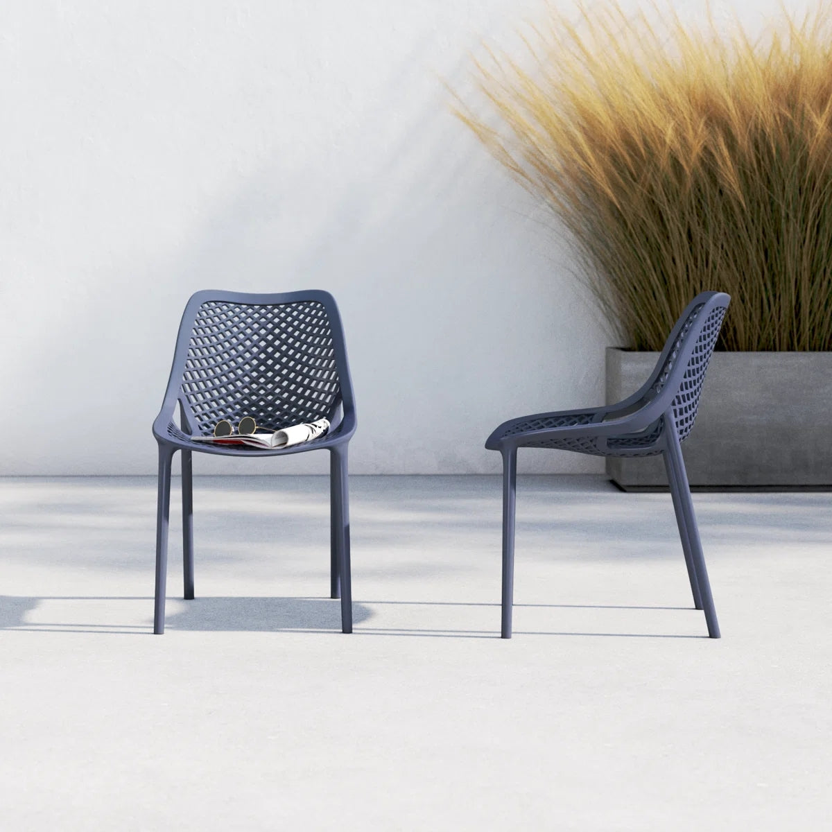 Two dark grey Replica Bilros Chairs on a patio, suitable for indoor and outdoor use