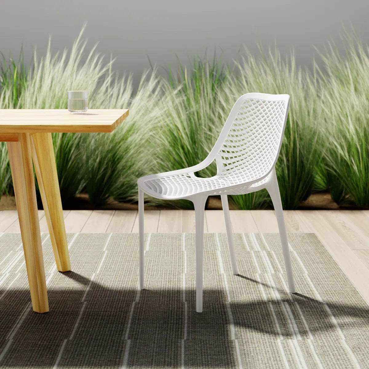 A white Replica Bilros Chair at a wooden table on a patio, suitable for indoor and outdoor use