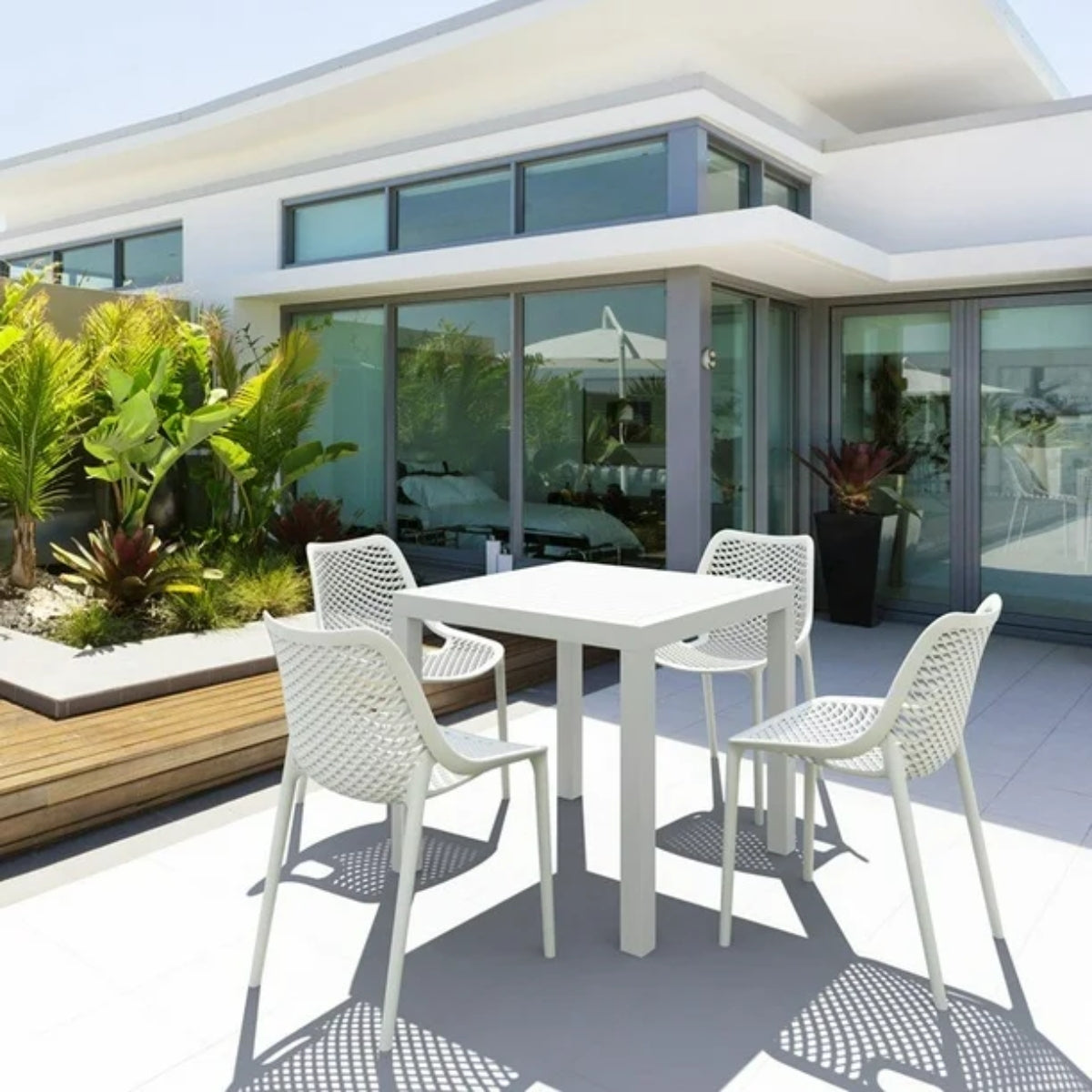 White Replica Bilros Chairs around dining tables on a modern outdoor patio, suitable for indoor and outdoor use