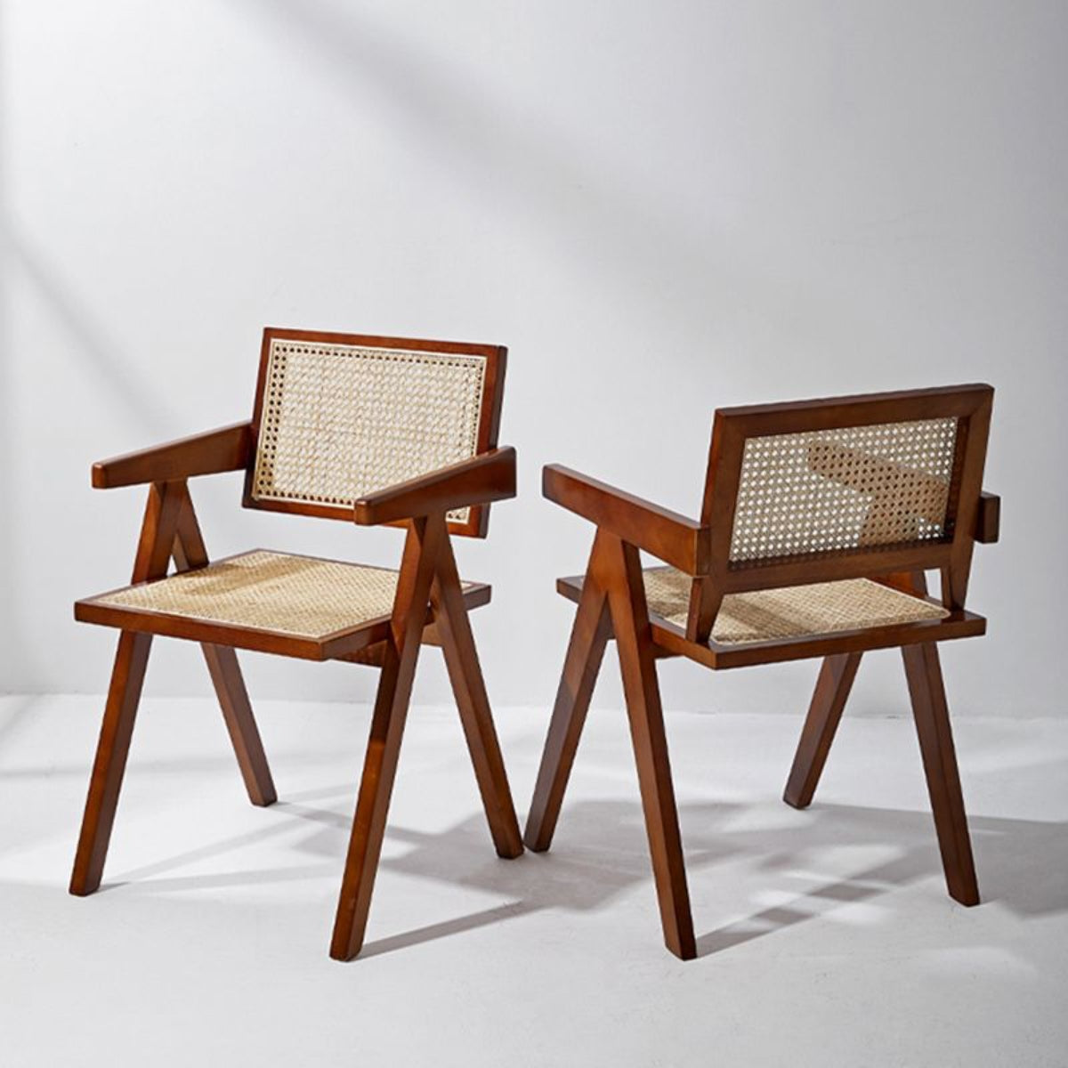 replica jeanneret armchair rattan and solid wood brown side by side