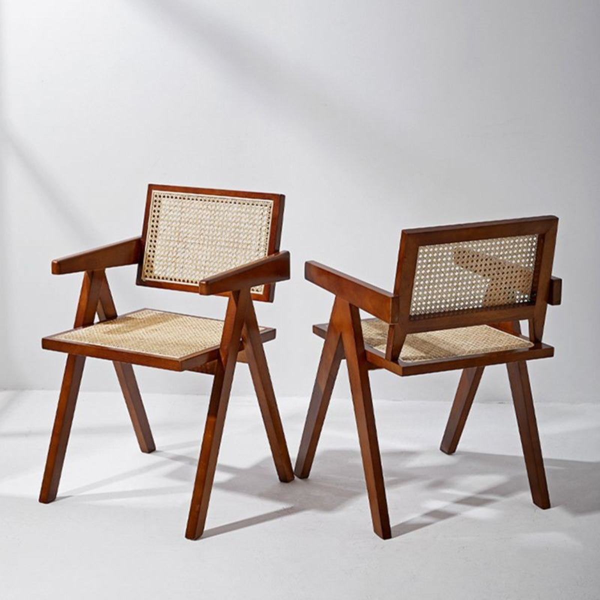 replica jeanneret armchair rattan and solid wood brown side by side