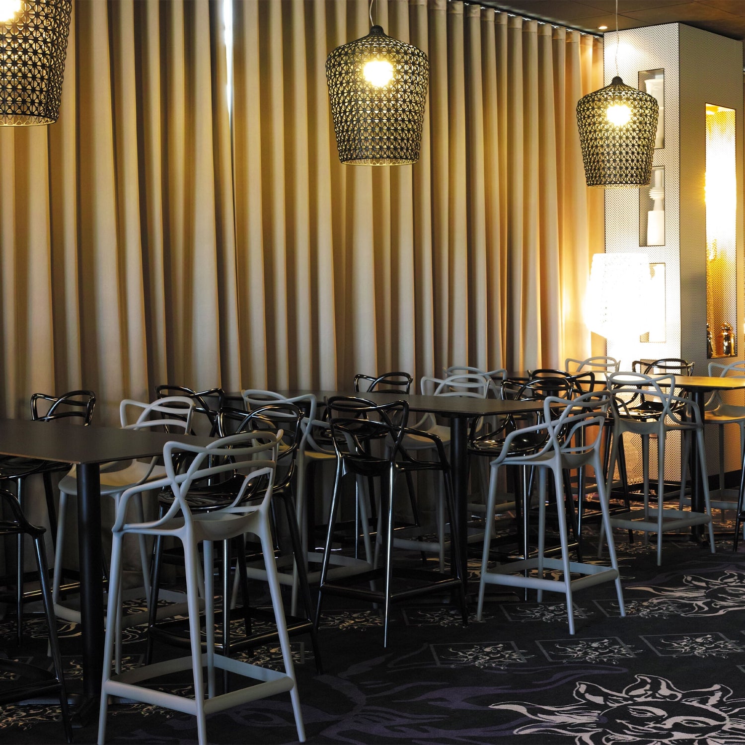 Grey, and black Replica Masters Bar Stools arranged in a modern commercial setting, demonstrating their versatility.