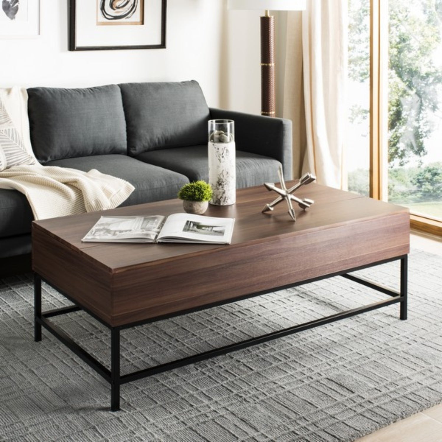 A contemporary living room featuring a plush couch, Askov Coffee Table, and a chic rug.