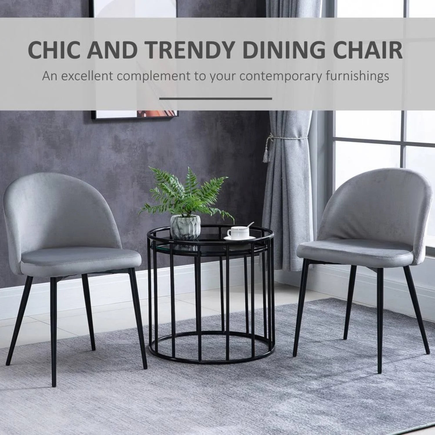 Two modern grey velvet dining chairs placed together with a table in the center.